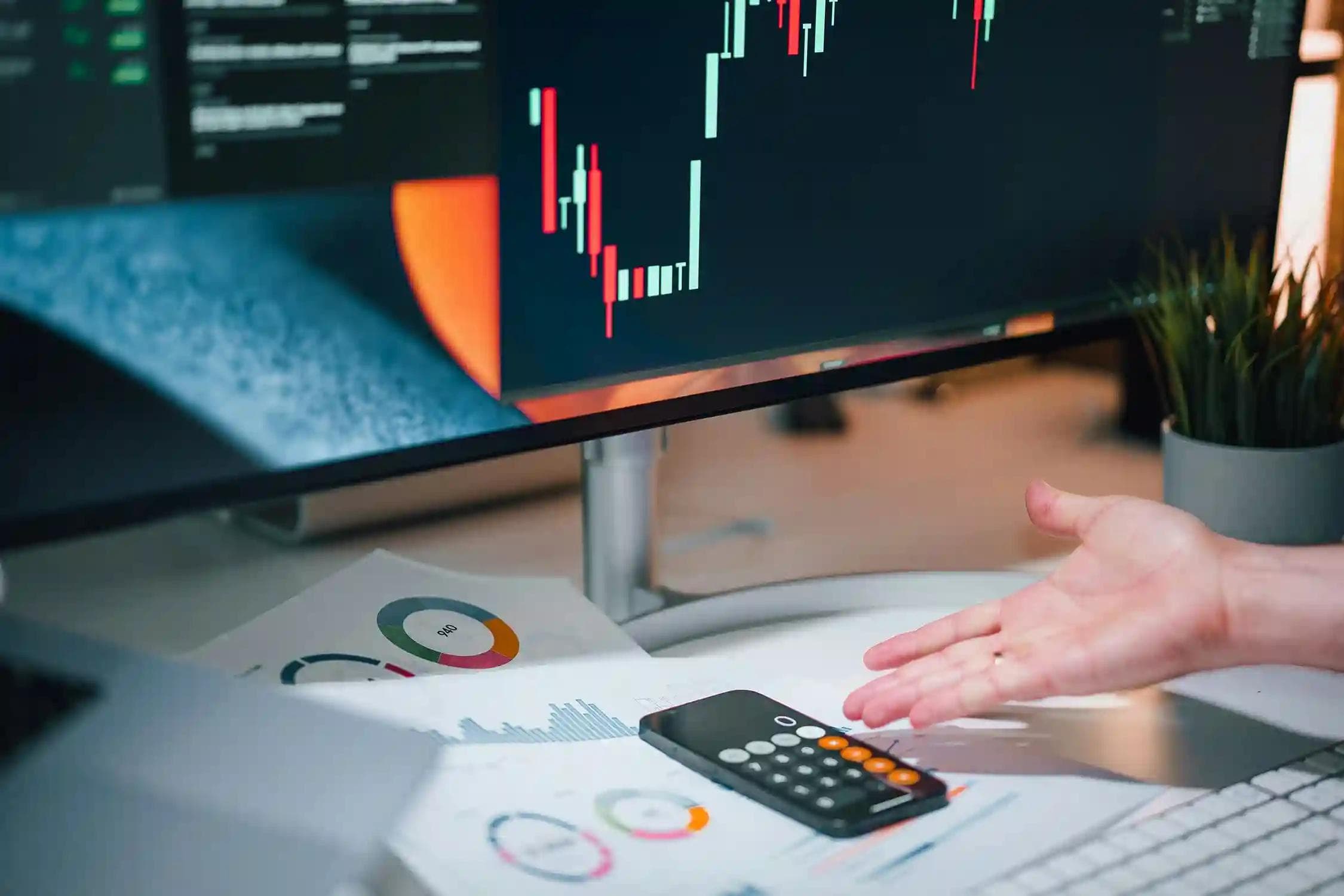 Prop firm trading analysis with market charts, performance reports, and trading calculator on desk
