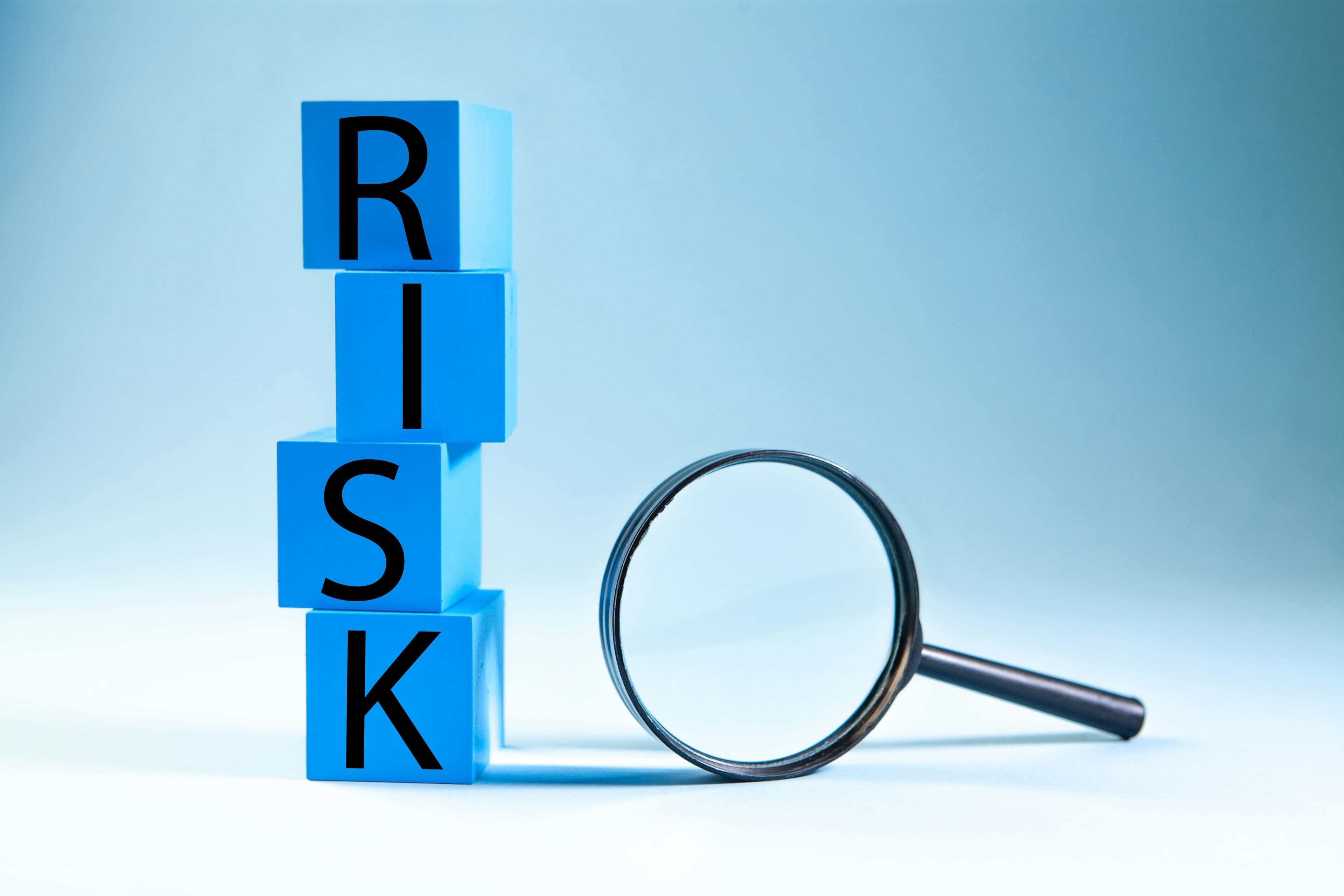 Prop firm risk analysis concept represented by risk blocks and magnifying glass